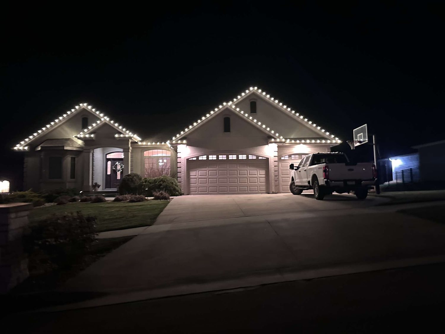 Stucco home with white lights along every peak