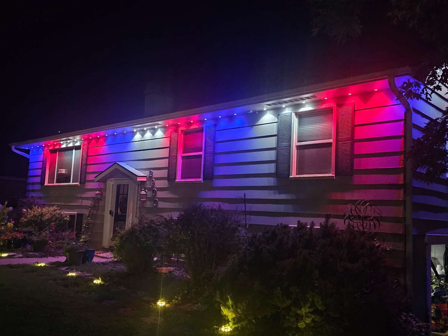 Split-level home lit in red, white and blue